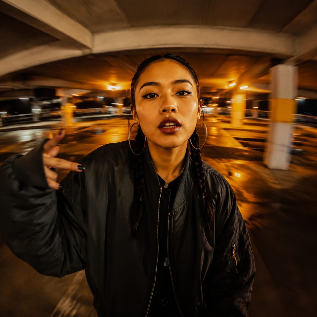 Rapper walking a parking deck at night